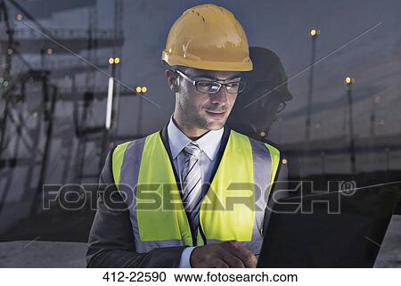 Stock Image - Businessman wearing protective workwear near window. Fotosearch