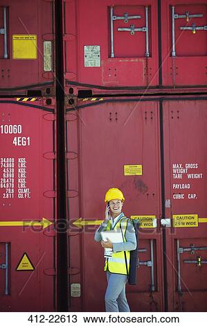 Businesswoman talking on cell phone near cargo containers View Large Photo Image Stock Image - Businesswoman talking on cell phone near cargo containers. Fotosearch