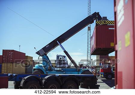 Picture - Crane lifting cargo container. Fotosearch