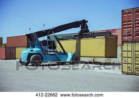Stock Image - Crane lifting cargo container. Fotosearch