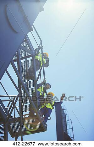 Low angle view of worker and businessmen on cargo crane View Large Photo Image Stock Photo - Low angle view of worker and businessmen on cargo crane. Fotosearch