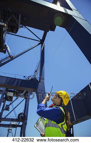 Low angle view of worker using walkie-talkie under cargo crane View Large Photo Image Stock Image - Low angle view of worker using walkie-talkie under cargo crane. Fotosearch