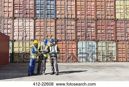 Worker and businessmen talking near cargo containers View Large Photo Image Stock Photo - Worker and businessmen talking near cargo containers. Fotosearch