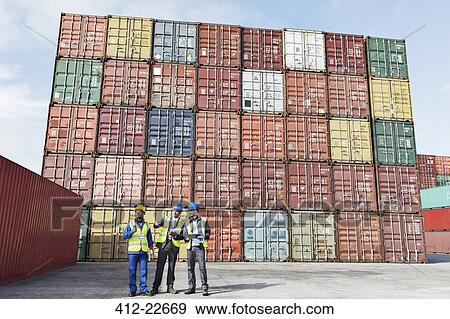 Worker and businessmen talking near cargo containers View Large Photo Image Stock Photo - Worker and businessmen talking near cargo containers. Fotosearch