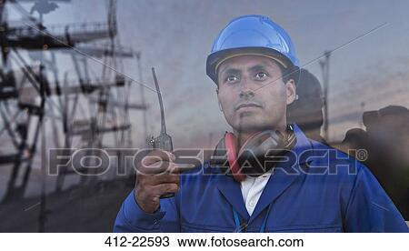 Worker holding walkie-talkie near window View Large Photo Image Stock Image - Worker holding walkie-talkie near window. Fotosearch