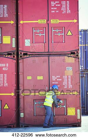 Stock Photograph - Worker opening cargo container. Fotosearch