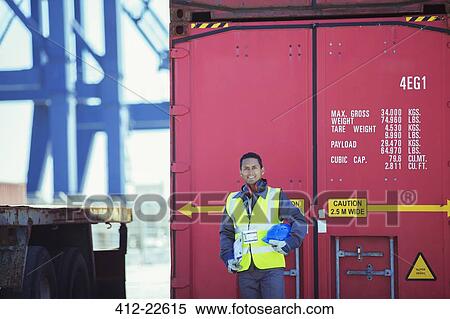 Stock Photography - Worker smiling near cargo container. Fotosearch