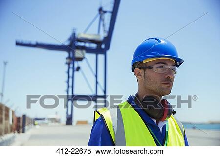 Worker standing near cargo crane View Large Photo Image Stock Photography - Worker standing near cargo crane. Fotosearch