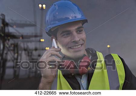 Stock Photography - Worker talking on cell phone near window. Fotosearch