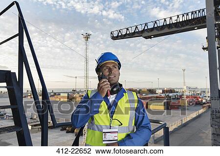 Worker using walkie-talkie on cargo crane View Large Photo Image Stock Image - Worker using walkie-talkie on cargo crane. Fotosearch