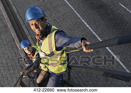 Stock Image - Workers standing on staircase. Fotosearch