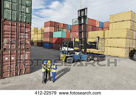 Workers talking near cargo containers View Large Photo Image Stock Photo - Workers talking near cargo containers. Fotosearch