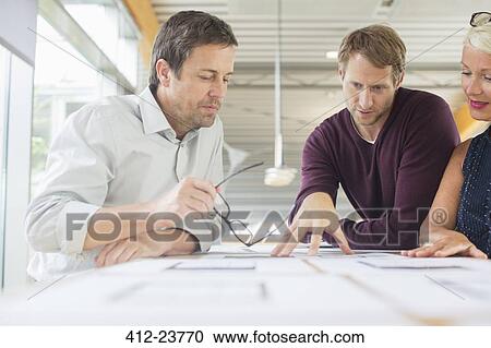 Business people reading paperwork in office meeting View Large Photo Image Stock Image - Business people reading paperwork in office meeting. Fotosearch