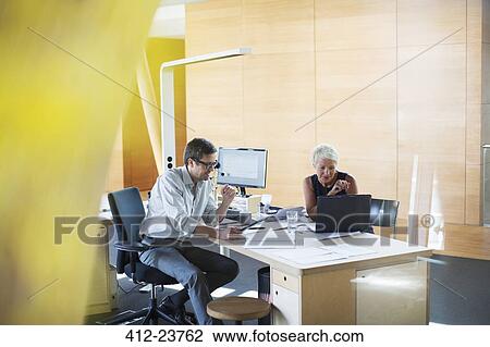 Business people talking at office desk View Large Photo Image Stock Image - Business people talking at office desk. Fotosearch