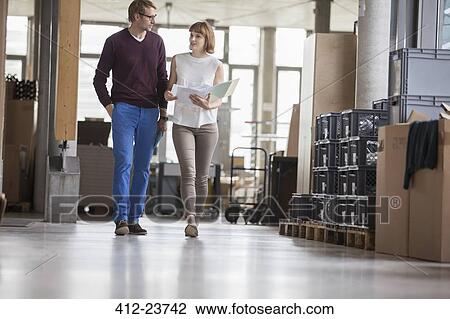 Stock Image - Business people walking in office. Fotosearch