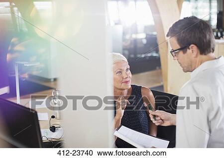 Stock Image - Business people working together in office. Fotosearch
