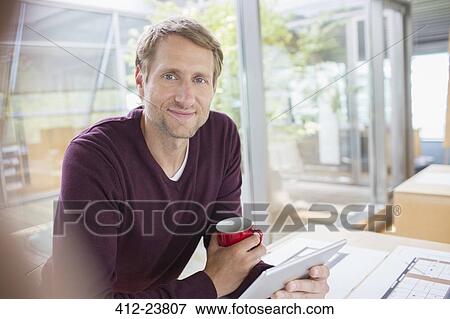 Businessman using digital tablet at office desk View Large Photo Image Stock Photo - Businessman using digital tablet at office desk. Fotosearch