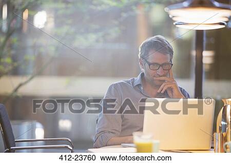 Businessman working on laptop in office View Large Photo Image Stock Image - Businessman working on laptop in office. Fotosearch