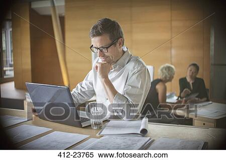 Businessman working on laptop in office View Large Photo Image Stock Photography - Businessman working on laptop in office. Fotosearch