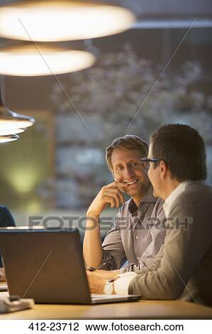 Stock Image - Businessmen talking in office meeting. Fotosearch