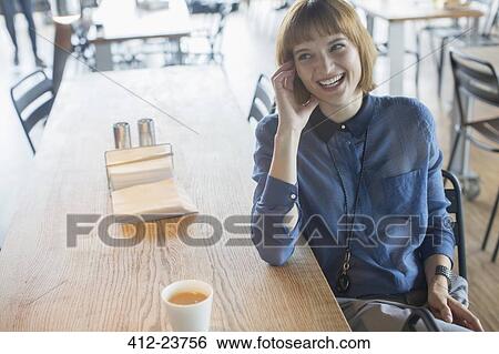 Businesswoman laughing at cafeteria table View Large Photo Image Stock Photograph - Businesswoman laughing at cafeteria table. Fotosearch