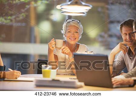 Stock Photograph - Businesswoman smiling in office meeting. Fotosearch