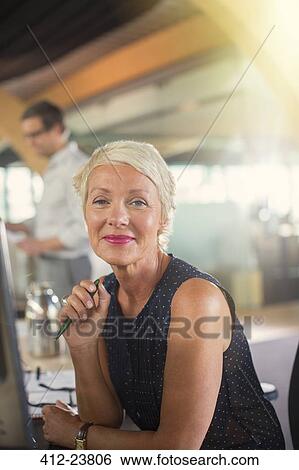 Stock Photograph - Businesswoman smiling in office. Fotosearch