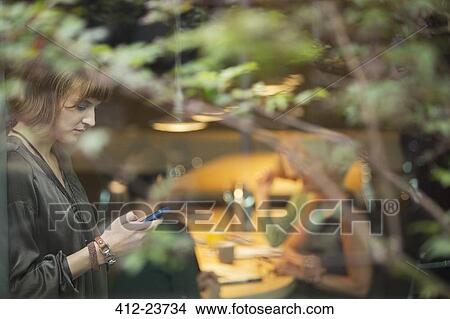 Businesswoman using cell phone in office View Large Photo Image Picture - Businesswoman using cell phone in office. Fotosearch