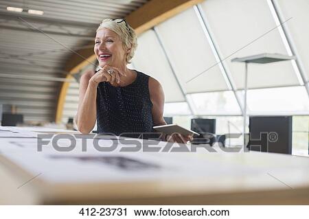 Stock Image - Businesswoman using digital tablet in office. Fotosearch