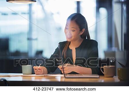 Stock Photo - Businesswoman writing in office. Fotosearch