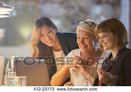 Stock Image - Businesswomen talking in office meeting. Fotosearch