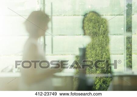 Stock Photo - Defocused view of businesswomen talking in office. Fotosearch
