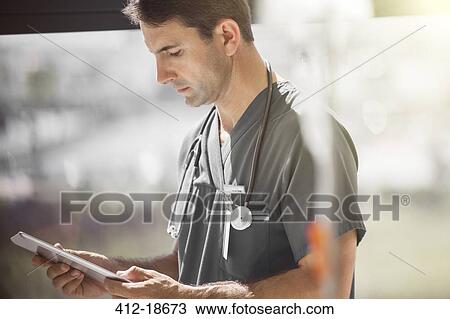 Stock Image - Dctor in hospital ward tablet pc . Fotosearch