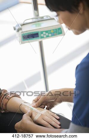 Doctor administering intravenous infusion to patient View Large Photo Image Stock Photo - Doctor administering intravenous infusion to patient. Fotosearch