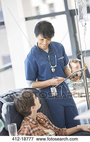Doctor attending patient receiving intravenous infusion in hospital View Large Photo Image Stock Photo - Doctor attending patient receiving intravenous infusion in hospital. Fotosearch