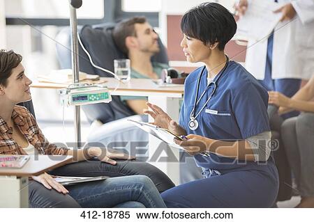 Doctor attending patients receiving intravenous infusion in hospital View Large Photo Image Stock Photography - Doctor attending patients receiving intravenous infusion in hospital. Fotosearch