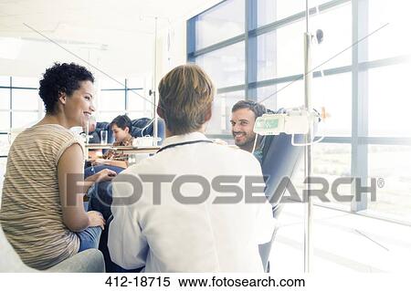 Doctor talking to patient receiving medical treatment in hospital ward View Large Photo Image Stock Photography - Doctor talking to patient receiving medical treatment in hospital ward. Fotosearch