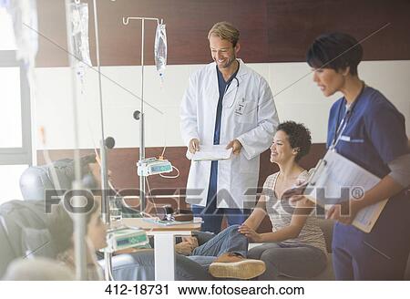Doctors attending patients receiving intravenous infusion in hospital View Large Photo Image Stock Image - Doctors attending patients receiving intravenous infusion in hospital. Fotosearch