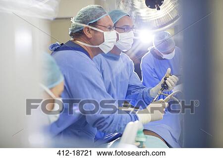 Doctors performing surgery in operating theater View Large Photo Image Stock Image - Doctors performing surgery in operating theater. Fotosearch