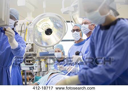 Doctors performing surgery in operating theater, looking at monitor View Large Photo Image Stock Photo - Doctors performing surgery in operating theater, looking at monitor. Fotosearch