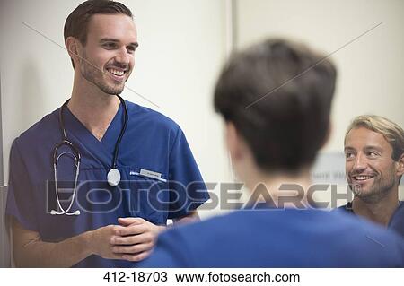 Doctors smiling and talking in hospital ward View Large Photo Image Stock Image - Doctors smiling and talking in hospital ward. Fotosearch