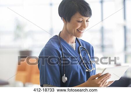 Female doctor using tablet pc in hospital View Large Photo Image Stock Image - Female doctor using tablet pc in hospital. Fotosearch