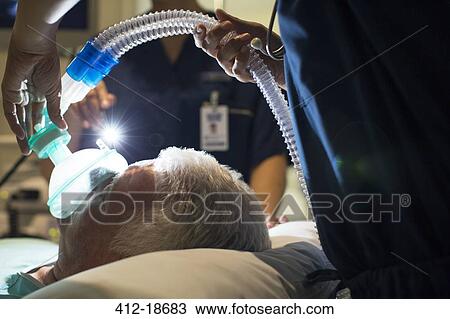 Female doctor wearing mask while anesthetizing elderly patient in surgery View Large Photo Image Stock Image - Female doctor wearing mask while anesthetizing elderly patient in surgery. Fotosearch