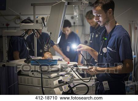 Group of doctors caring for patient in hospital ward View Large Photo Image Stock Image - Group of doctors caring for patient in hospital ward. Fotosearch
