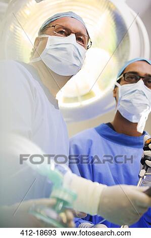 Low angle view of mature doctors performing surgery View Large Photo Image Stock Image - Low angle view of mature doctors performing surgery. Fotosearch
