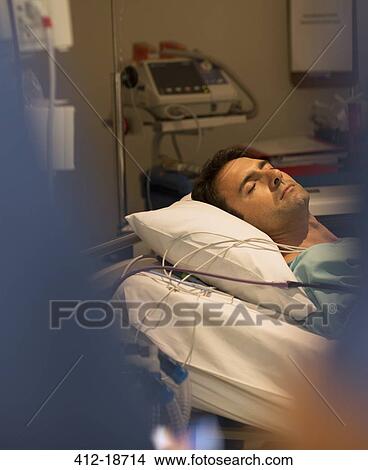 Picture - Male patient sleeping in hospital bed. Fotosearch