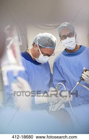 Mature doctors performing surgery and controlling liquid in saline bag View Large Photo Image Stock Image - Mature doctors performing surgery and controlling liquid in saline bag. Fotosearch