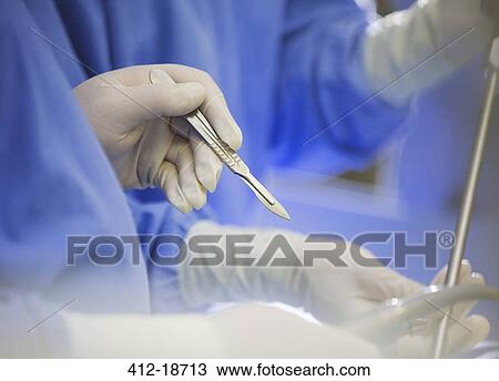 Mature surgeon using scalpel during surgery View Large Photo Image Stock Image - Mature surgeon using scalpel during surgery. Fotosearch