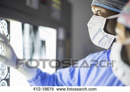 Mid adult man examining patient's MRI View Large Photo Image Stock Photography - Mid adult man examining patient's MRI. Fotosearch