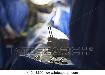Nurse holding surgical tools during surgery View Large Photo Image Stock Photo - Nurse holding surgical tools during surgery. Fotosearch